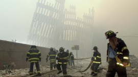 Firefighters work beneath the destroyed mullions, the vertical struts which once faced the soaring outer walls of the World Trade Center towers, after a terrorist attack in New York, Sept. 11, 2001. (AP, file)