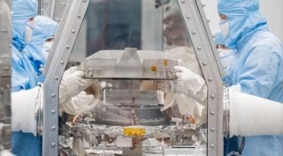 Experts remove the lid of the OSIRIS-REx asteroid bennu sample return canister.