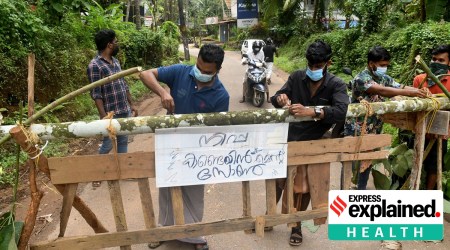 Residents fix a sign reading "Nipah containment zone" on a barricade in Ayanchery village