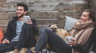 A man and a woman, seemingly a couple, having coffee together.