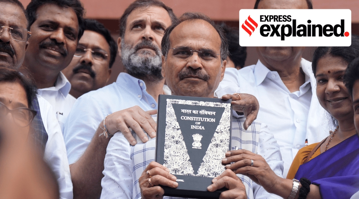 Congress leaders Adhir Ranjan Chowdhury and Rahul Gandhi outside Parliament, holding a copy of the constitution.