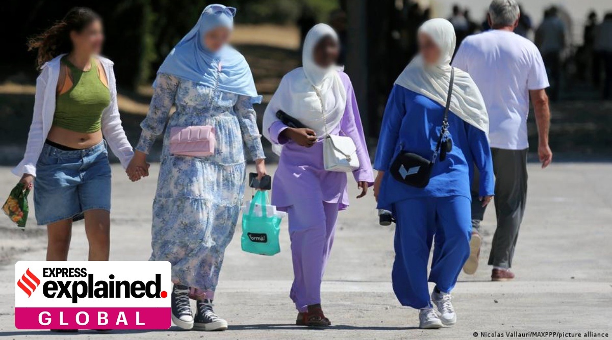 Women walking, wearing Abayas.