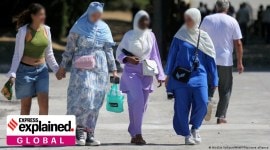 Women walking, wearing Abayas.