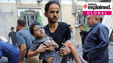 A man carries a wounded child at the site of an Israeli strike in Khan Younis in the southern Gaza Strip October 19, 2023.