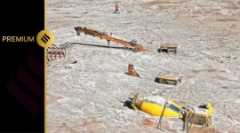 A man walks past construction vehicles covered in debris caused by flash floods after a lake burst in Rangpo, Sikkim, October 8, 2023. REUTERS