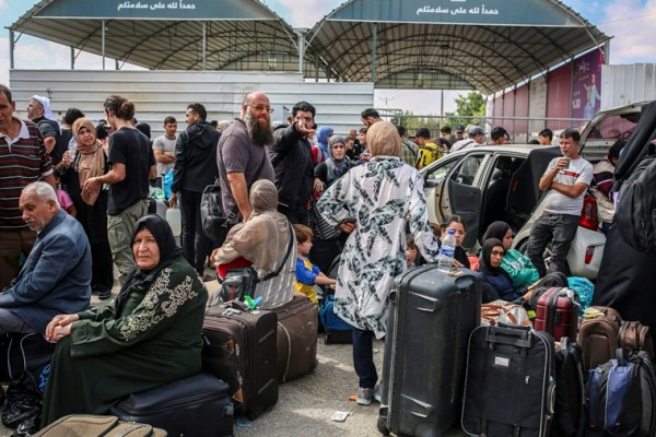 People gather on the Gaza side of the closed Rafah border crossing with Egypt on Monday, Oct. 16, 2023.