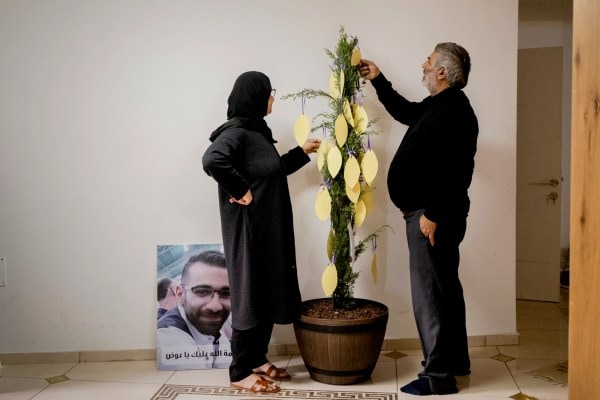 The parents of Awad Darawshe, from left, Mousa and Hoda, read notes left for them by Awad’s classmates at their home in Iksal, Israel, on Oct. 20, 2023. Long derided as naïve, even traitors, the bridge builders between Israelis and Palestinians sense opportunity in the aftermath of the Hamas attack. (Amit Elkayam/The New York Times)