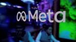 People are seen behind a logo of Meta Platforms, during a conference in Mumbai, India, September 20, 2023.