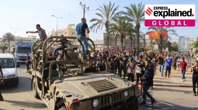Palestinians ride on an Israeli military vehicle taken by an army base overrun by Hamas militants near the Gaza Strip fence, in Gaza City, Saturday, Oct. 7, 2023.