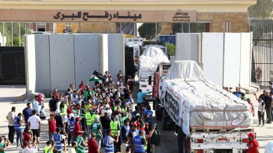 Trucks carrying humanitarian aid from Egyptian NGOs drive through the Rafah crossing from the Egyptian side in Rafah