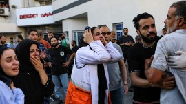 A Palestinian medic, center, and others cry after learning about the death of a relative at the al-Shifa hospital, following Israeli airstrikes on Gaza City, central Gaza Strip, Tuesday, Oct. 17, 2023. (AP Photo/Abed Khaled)