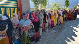 Voters queue up outside a polling booth to cast their votes