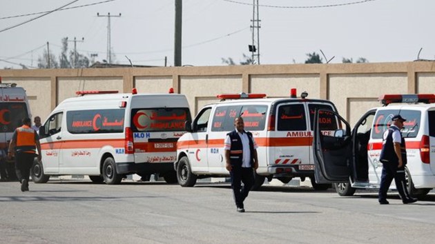 Medical workers wait to take Palestinians who will receive treatment in Egyptian hospitals, at the Rafah border crossing, in the southern Gaza Strip