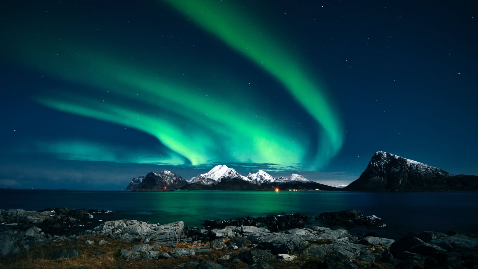 Image of a green aurora in the sky with mountains in the backdrop