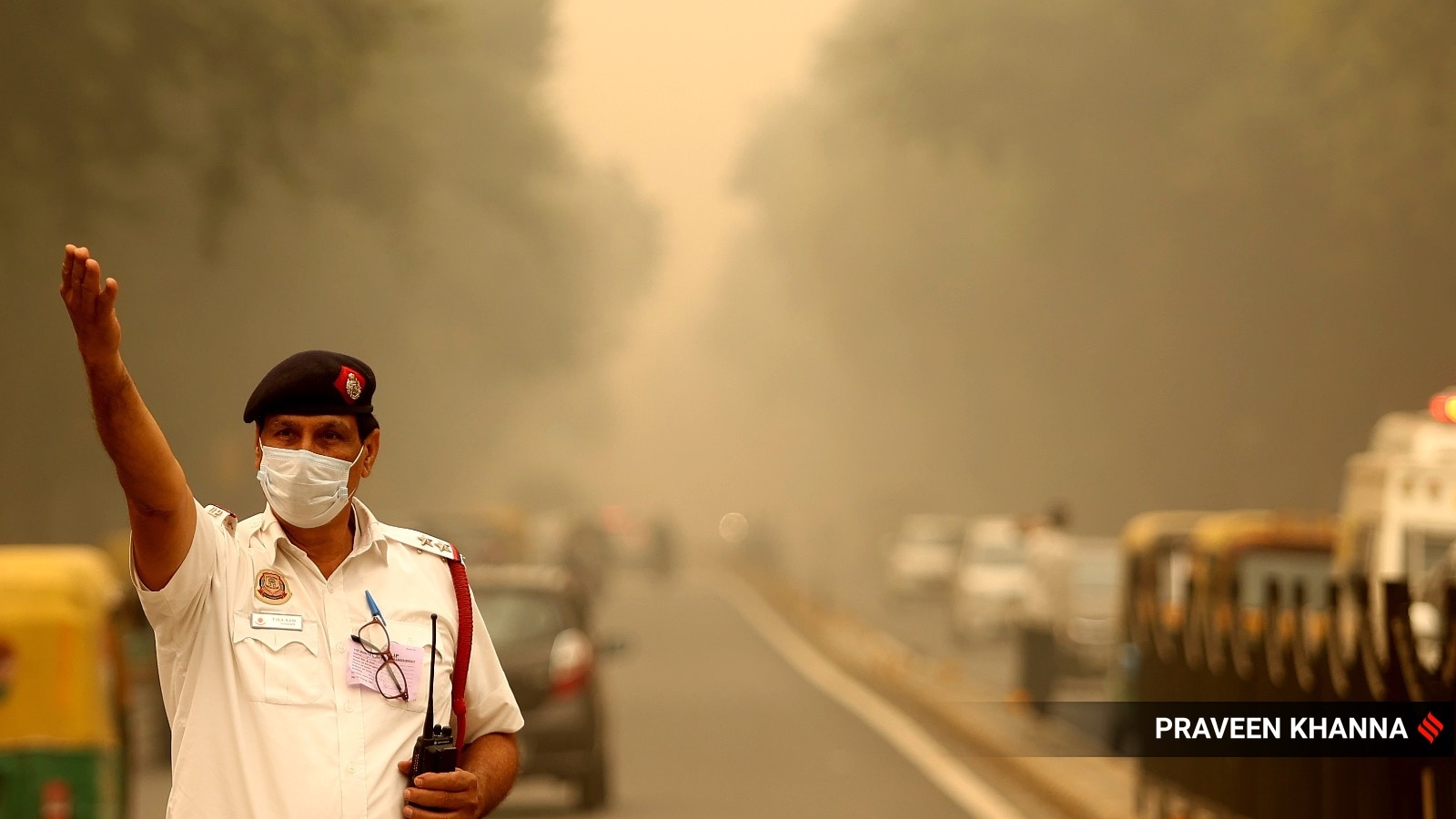 A traffic policeman wearing a mask under heavy smog in New Delhi on Friday. (Express photo by Praveen Khanna)