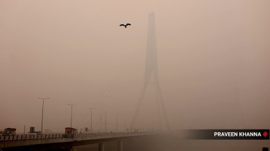 Signature Bridge is almost invisible due to heavy smog in New Delhi on Friday. Pollution AQI crossed 540, affected visibility also. (Express photot by Praveen Khanna)