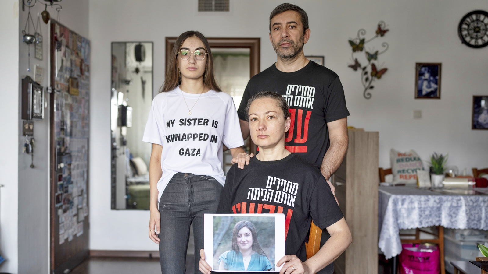 The Ariev family, parents Albert and Ira and their daughter Sasha, hold up a portrait of young soldier Karina Ariev in their family house in Jerusalem, Sunday, Oct. 29, 2023. Ariev, an Israeli soldier, was abducted by Hamas militants from her base during her mandatory military service during the militant group's unprecedented attack on Israel on Oct. 7 that resulted in the killing of 1,400 people and the abduction of over 220. (AP Photo/Ohad Zwigenberg).