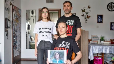 The Ariev family, parents Albert and Ira and their daughter Sasha, hold up a portrait of young soldier Karina Ariev in their family house in Jerusalem, Sunday, Oct. 29, 2023. Ariev, an Israeli soldier, was abducted by Hamas militants from her base during her mandatory military service during the militant group's unprecedented attack on Israel on Oct. 7 that resulted in the killing of 1,400 people and the abduction of over 220. (AP Photo/Ohad Zwigenberg).