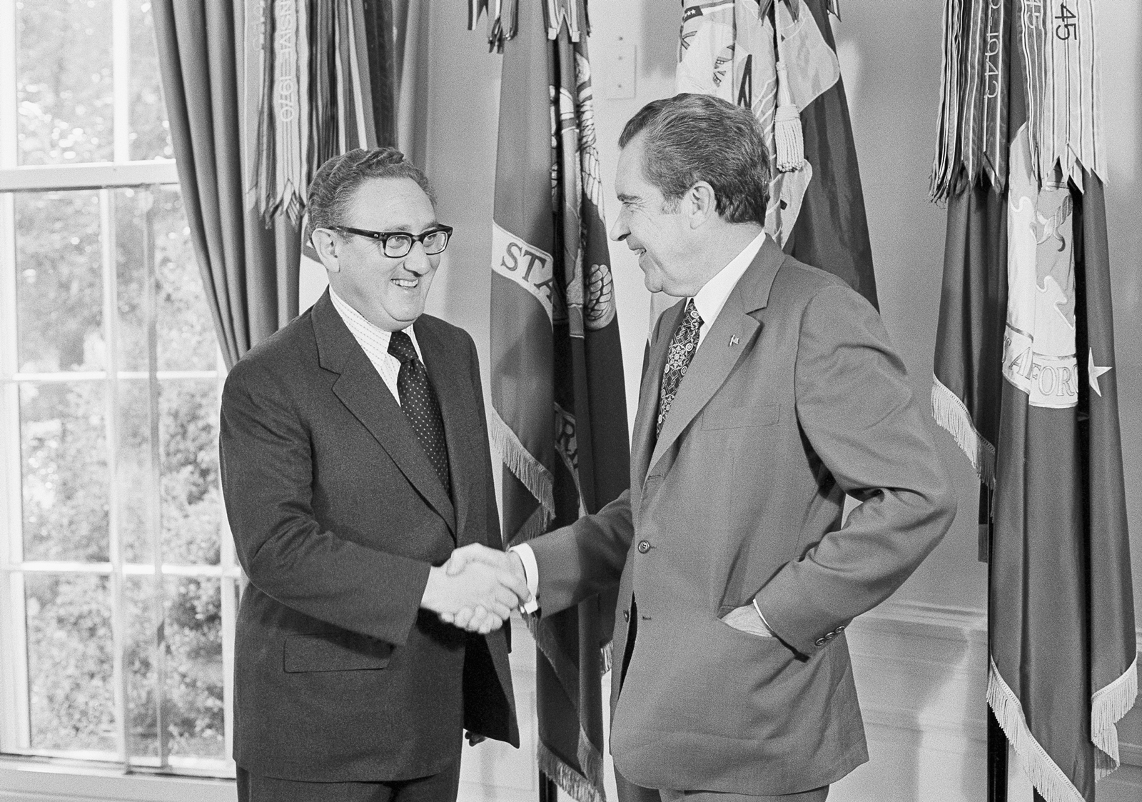 FILE - President Richard Nixon, right, offers his congratulations to Secretary of State Henry Kissinger, after the secretary won the 1973 Nobel Peace Prize, in the Oval Office of the White House in Washington, Oct. 16, 1973. Kissinger, the diplomat with the thick glasses and gravelly voice who dominated foreign policy as the United States extricated itself from Vietnam and broke down barriers with China, died Wednesday, Nov. 29, 2023. He was 100. (AP Photo/Jim Palmer, File)