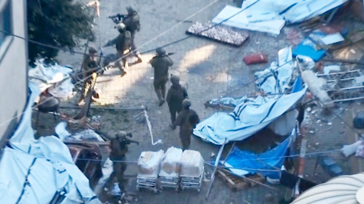 In this image taken from a video released by the Israeli Defense Forces on Wednesday, Nov. 15, 2023, Israeli soldiers walk in the area of Al-Shifa hospital in Gaza City. (Israel Defense Forces via AP)