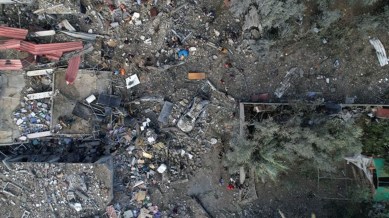 Palestinians gather at the site of Israeli strikes on houses, at the Maghazi camp in the central Gaza Strip