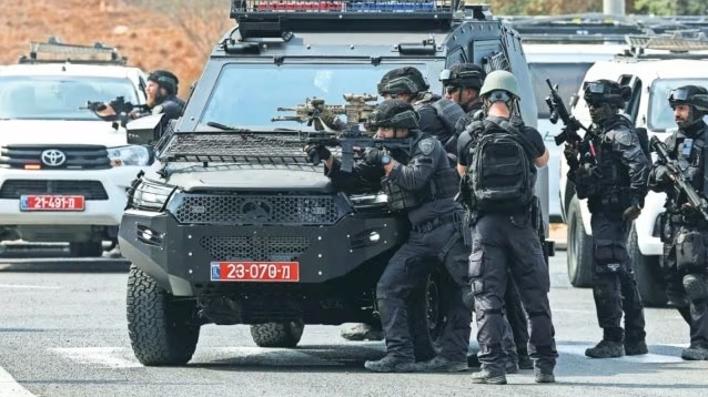 Israeli security stand in position on a road following a mass infiltration by Hamas gunmen from the Gaza Strip, near Sderot in southern Israel October 8, 2023. Reuters