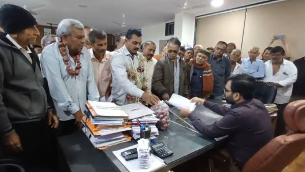Farmers give a memorandum and a bag of onions to sub-divisional magistrate of Dhoraji, in Dhoraji town of Rajkot district on Monday. Photo by Kishor Rathod