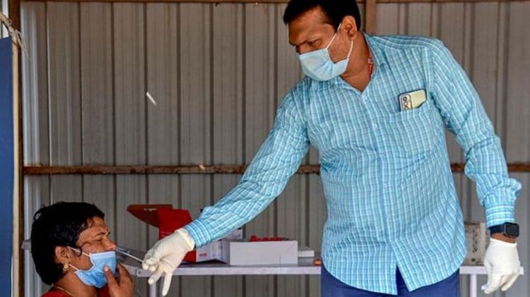 A healthcare worker takes the sample of a woman for Covid-19 testing, amid a rise in coronavirus cases in the country