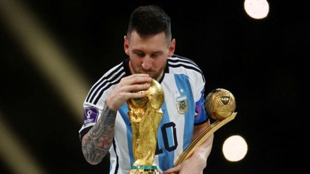 Argentina's Lionel Messi kisses the World Cup trophy aft  receiving the Golden Ball grant  arsenic  helium  celebrates aft  winning the World Cup REUTERS