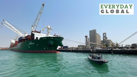 A coastguard boat sails past a commercial container ship docked at the Houthi-held Red Sea port of Hodeidah, as a container ship carrying general commercial goods docked at the port for the first time since at least 2016, in Hodeidah, Yemen February 25, 2023.