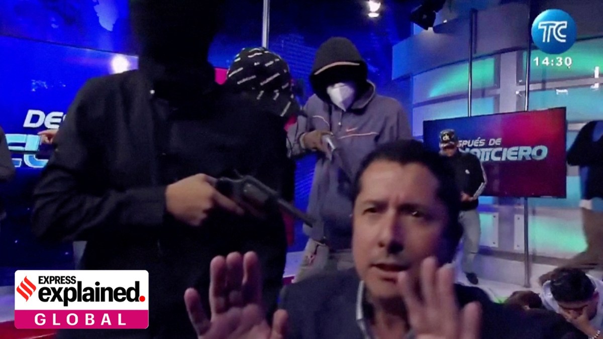 A hooded man points a gun at Ecuadorian TV presenter Jose Luis Calderon while on air inside Ecuador's TC television station, in Guayaquil, Ecuador, January 9, 2024, in this screen grab from video.