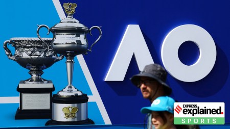 People pass by a trophy poster ahead of the Australian Open tennis tournament, at Melbourne Park, in Melbourne, Australia January 11, 2024.