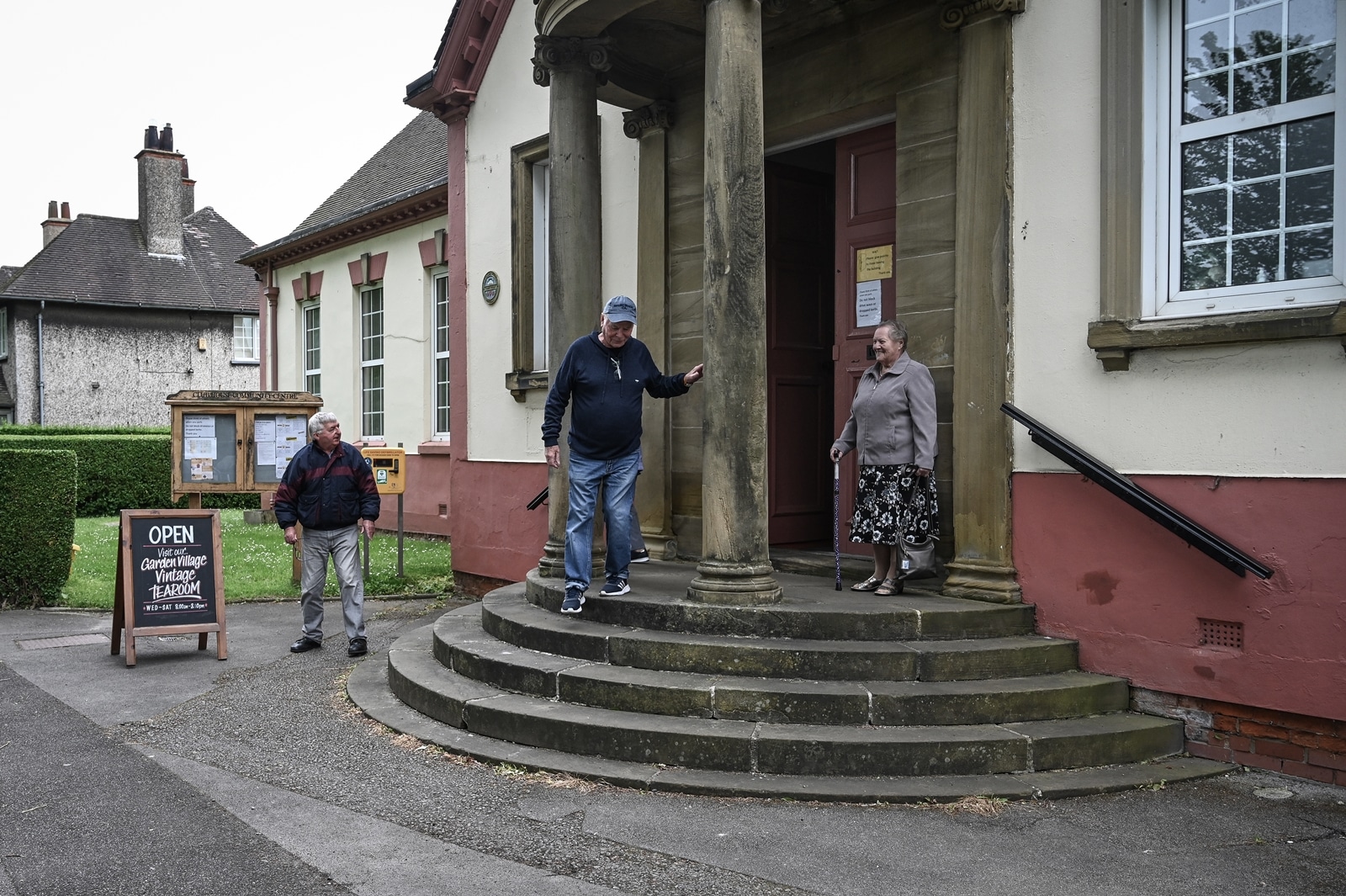 Men and women leave a community center in Hull, England after attending a social group run by the charity Age UK, on May 31, 2023. An “integrated care center” brings doctors, physiotherapists, social workers, and pharmacists under one roof. It won’t solve Britain’s underlying social care crisis — but it could help. (Mary Turner/The New York Times)