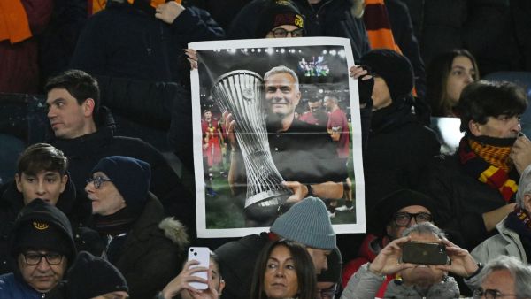 AS Roma fans hold up a picture of former manager Jose Mourinho inside the stadium before the match. (reuters)
