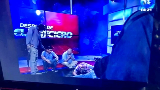 Workers lie on the floor as hooded and armed people take over a tv studio of Ecuador's TV station TC during a live broadcast, in this still image of a Reuters' recording of the affair of TC signal channel, in Guayaquil, Ecuador, January 9, 2024. Reuters Tv/via REUTERS ECUADOR OUT. NO COMMERCIAL OR EDITORIAL SALES IN ECUADOR. NO RESALES. NO ARCHIVES