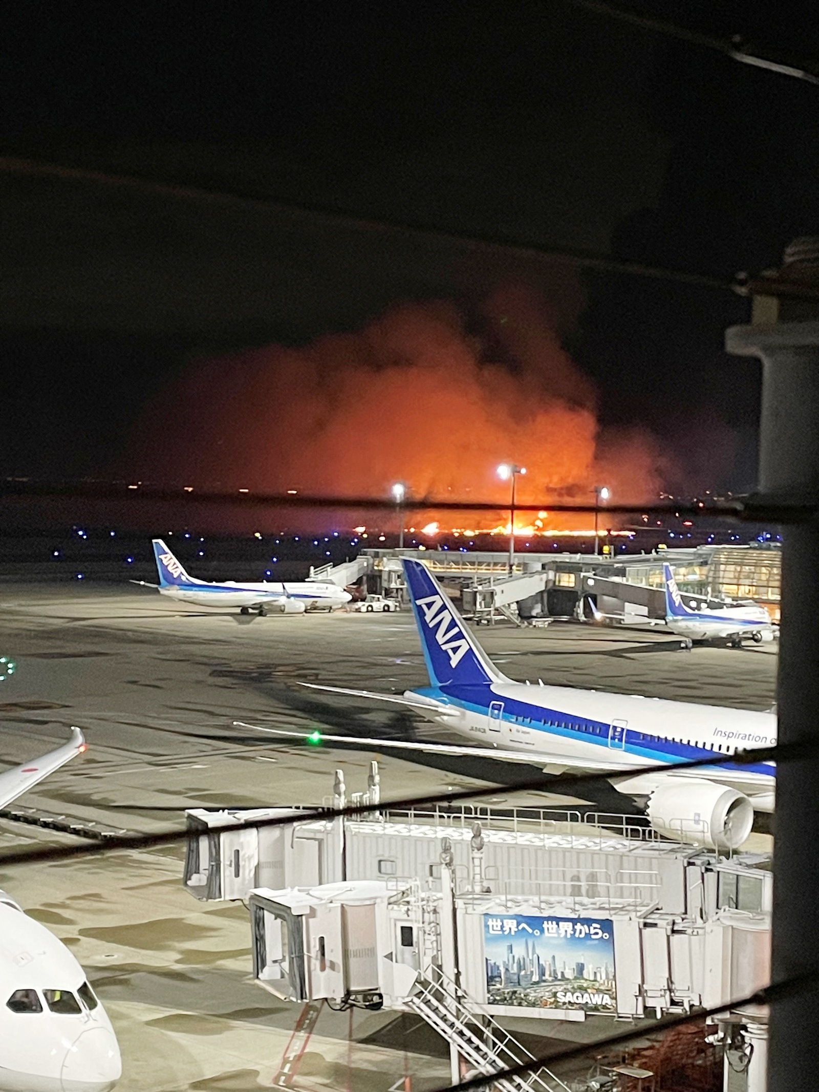 Smoke billows and flames rise after a Japan Airlines (JAL) plane collided with a Coast Guard aircraft on the ground, at Tokyo's Haneda airport, Japan, January 2, 2024 in this image obtained from social media. Obtained by Reuters/via REUTERS THIS IMAGE HAS BEEN SUPPLIED BY A THIRD PARTY.