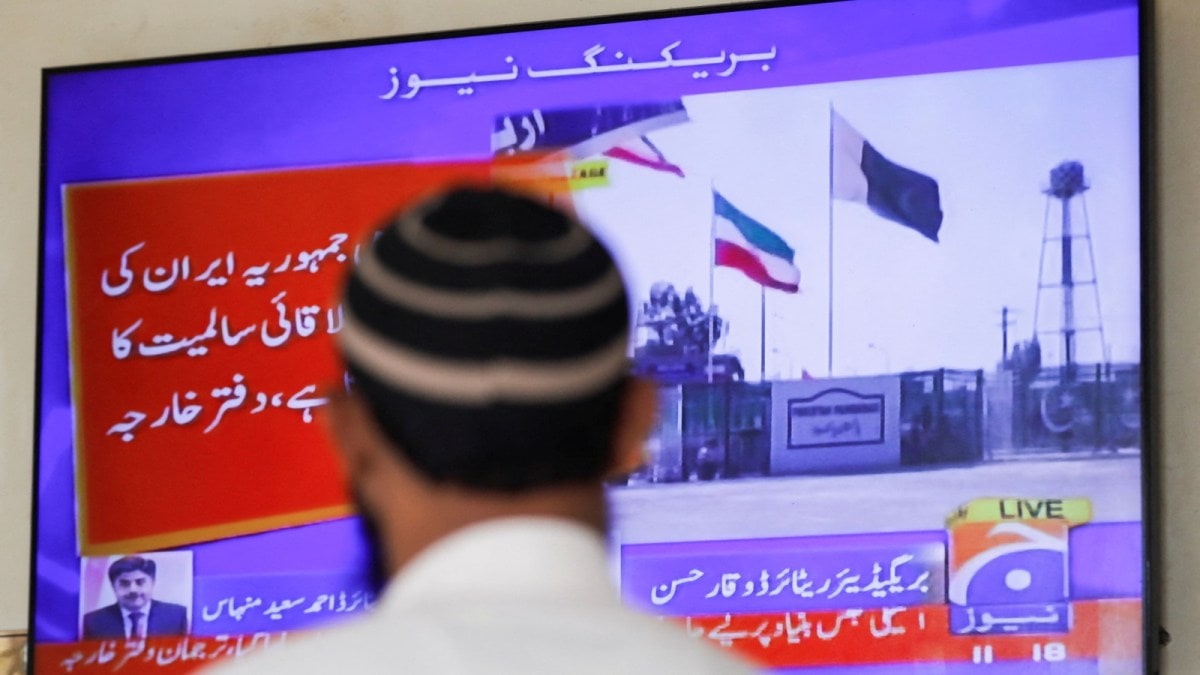 A man looks at a television screen after the Pakistani foreign ministry said the country conducted strikes inside Iran targeting separatist militants, two days after Tehran said it attacked Israel-linked militant bases inside Pakistani territory, in Karachi, Pakistan January 18, 2024. REUTERS/Akhtar Soomro