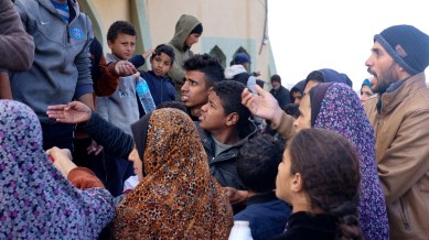 Palestinians wait to collect drinking water amid shortages, at a tent camp sheltering people who fled their houses due to Israeli strikes, in Rafah in the southern Gaza Strip January 28, 2024. REUTERS/Saleh Salem