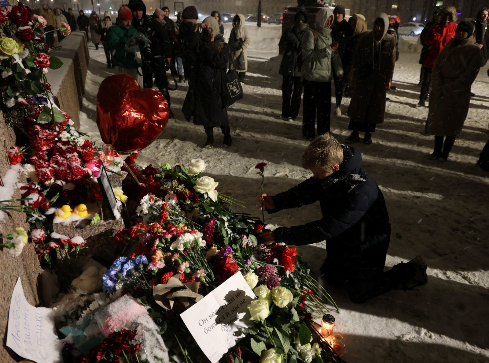 People gather at the monument to the victims of political repressions following the death of Alexei Navalny in Saint Petersburg
