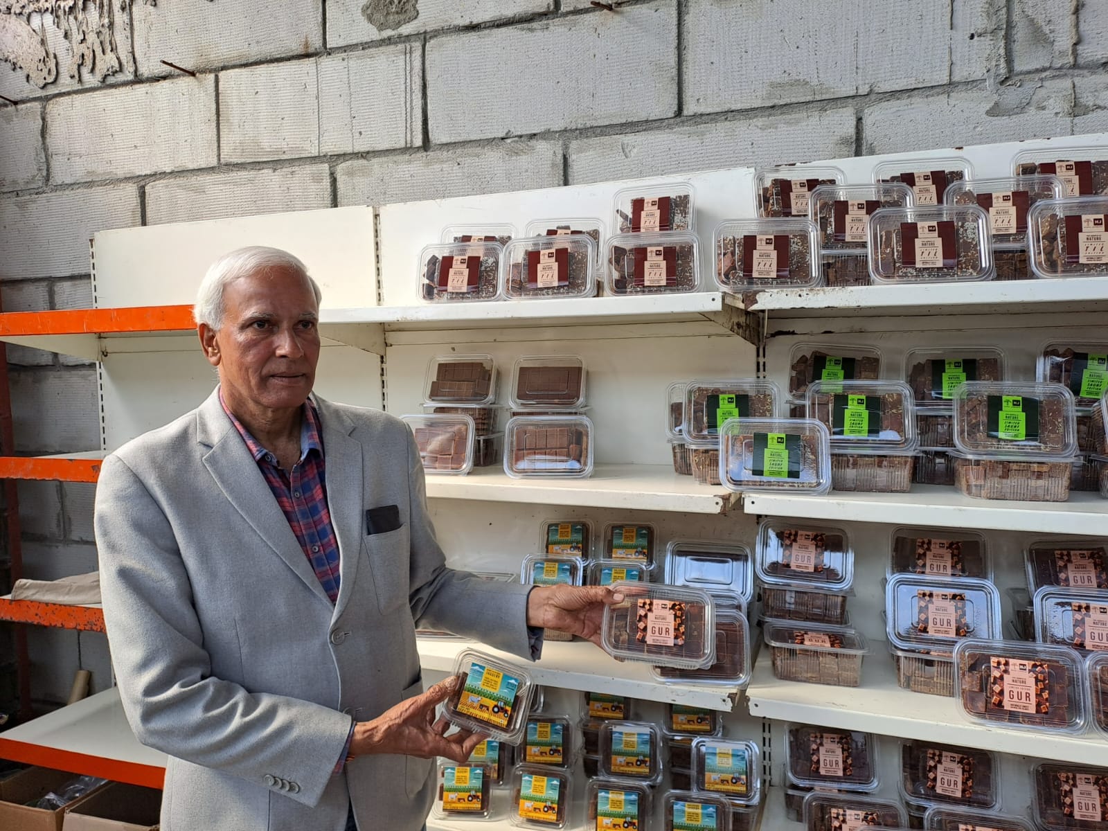 K.P. Singh displaying the "natural black and sweet" jaggery products from his gur plant.