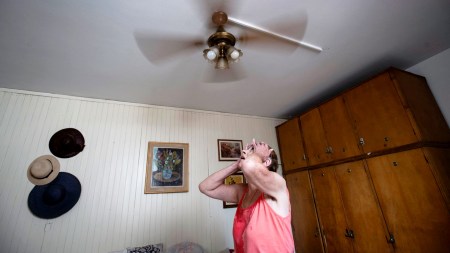 A woman stands under a ceiling fan amid a heat wave with temperatures rising. (Reuters, representational)