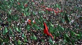 Supporters of the Grand Democratic Alliance (GDA), an alliance of political parties, carry flags as they gather for a sit-in protest against, what they call election rigging and are demanding free and fair results of the general elections along the main Highway in Jamshoro, Pakistan. (Reuters)