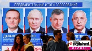 People gather near a screen showing the preliminary results of Russia's presidential election, at the headquarters of the Central Election Commission in Moscow, Russia, March 18, 2024. From L to R: Vladislav Davankov, Vladimir Putin, Leonid Slutsky and Nikolai Kharitonov.
