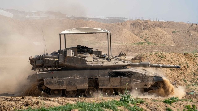 Israeli soldiers operate a tank in the Gaza Strip