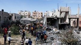 Palestinians gather at the site of an Israeli strike on a house, in Rafah