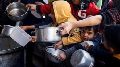 Palestinian children wait to receive food cooked by a charity kitchen amid shortages of food supplies, as the conflict between Israel and the Palestinian Islamist group Hamas continues, in Rafah, in the southern Gaza Strip, March 5, 2024. (Reuters)