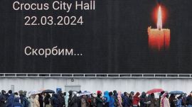 People line up to lay flowers at a makeshift memorial to the victims of a shooting attack set up outside the Crocus City Hall concert venue in the Moscow Region