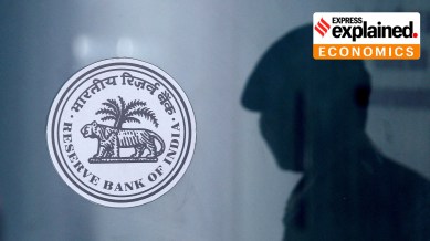 A security guard's reflection is seen next to the logo of the Reserve Bank Of India (RBI) at the RBI headquarters in Mumbai, India, June 6, 2019.