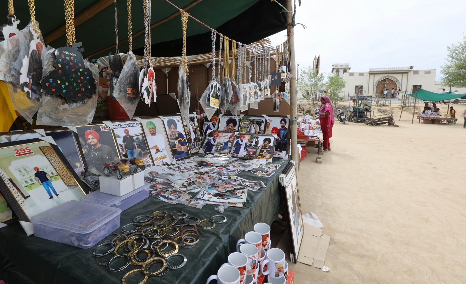 Vendors selling Moosewala merchandise outside his mansion. They say the singer has given them a means of livelihood even after his death. (Express Photo by Gurmeet Singh)