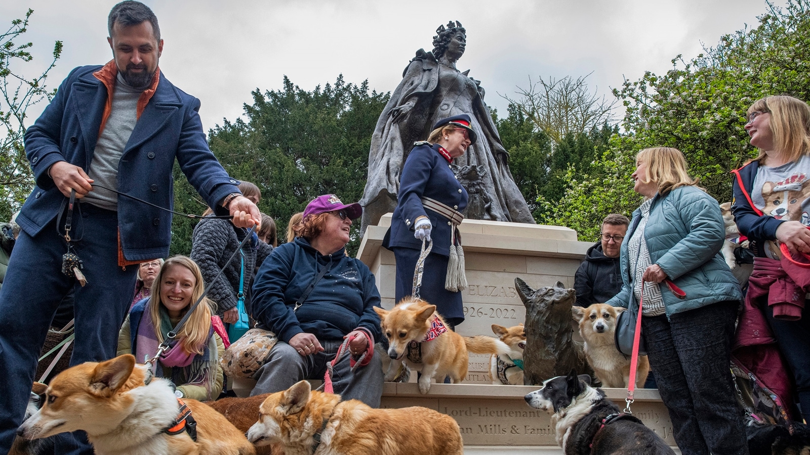 Fans of Queen Elizabeth II and members of the Welsh Corgi League gather after the unveiling of Britain’s first memorial statue to the monarch at the Oakham Library Gardens in Oakham, England, April 21, 2024. (Joshua Bright/The New York Times)